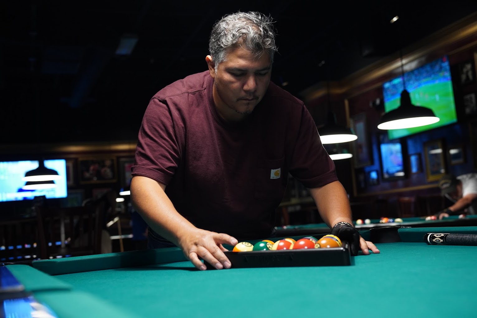 Player racking the balls in the triangle before the next game.