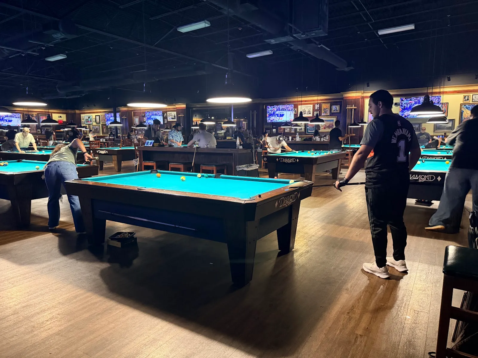 League night at Fast Eddie's Braun: several tables in play, players down on shots and others watching from the rail.