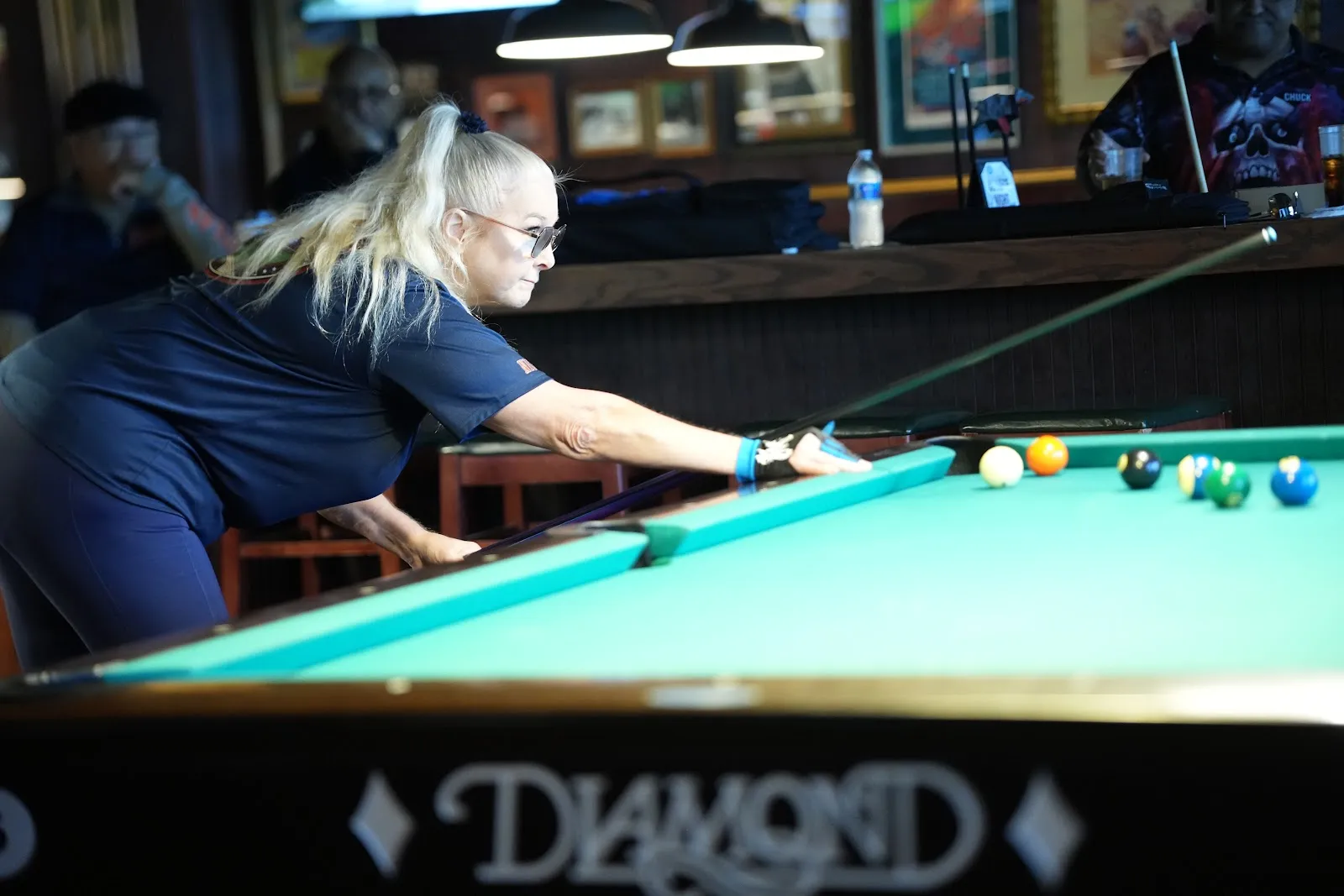 A player lining up a shot along the rail of a Diamond table.