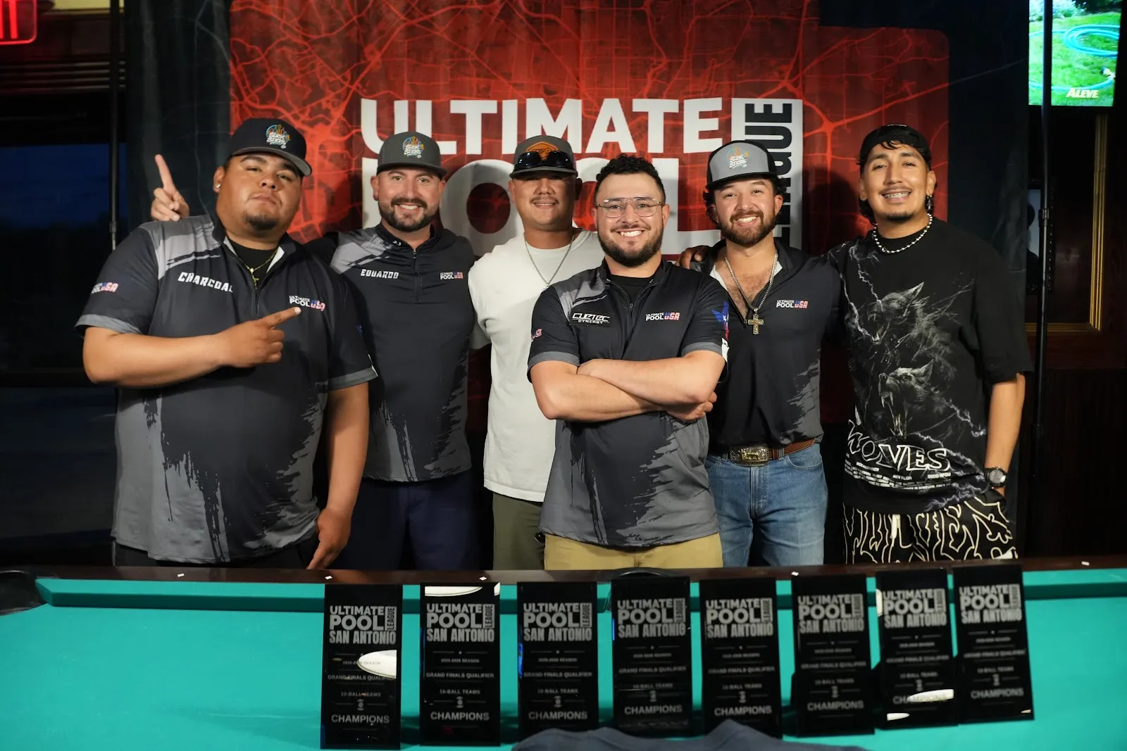 The 2026 10-Ball Grand Finals Qualifier champions posing with their trophies at the Ultimate Pool League San Antonio banner.